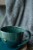 Zbliżenie na dekoracyjny napis na zielono-morskim kubku ceramicznym 400 ml handmade