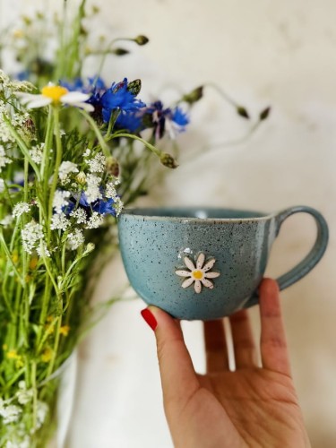 Filiżanka ceramiczna z kwiatem 300 ml turkusowa trzymana w dłoni handmade